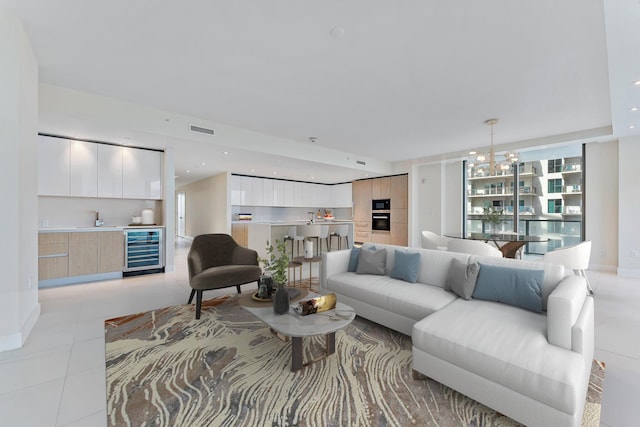 living room featuring light tile patterned floors, recessed lighting, beverage cooler, visible vents, and baseboards