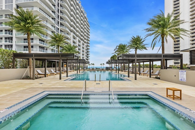 view of swimming pool with a hot tub