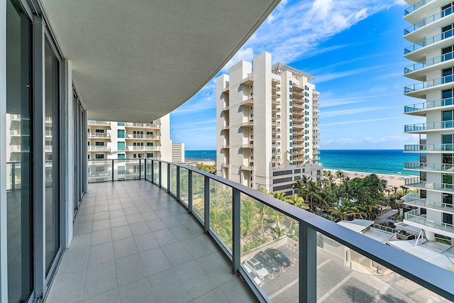 balcony with a water view and a view of the beach