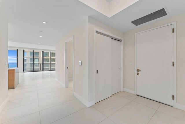 hall with light tile patterned flooring and expansive windows