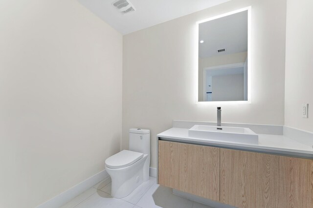 bathroom with vanity, tile patterned flooring, and toilet