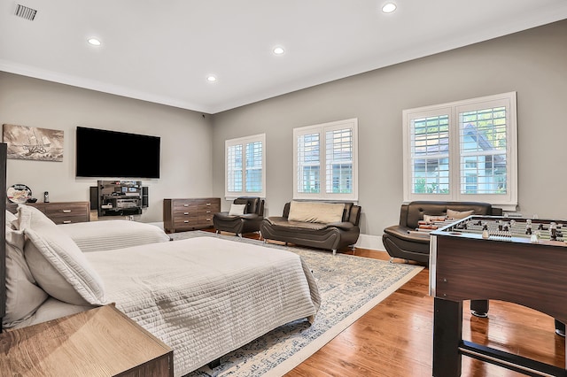 bedroom with light wood-type flooring and crown molding