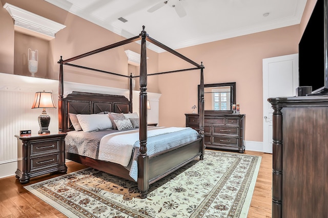 bedroom with light hardwood / wood-style floors, ceiling fan, and crown molding