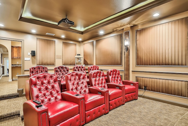 carpeted home theater featuring a raised ceiling