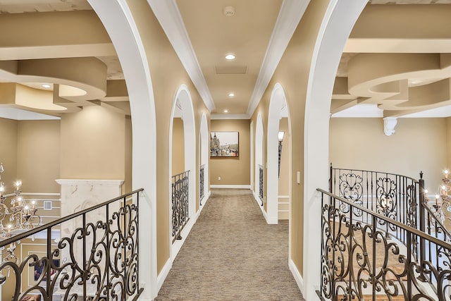 hallway with carpet floors, crown molding, and a notable chandelier