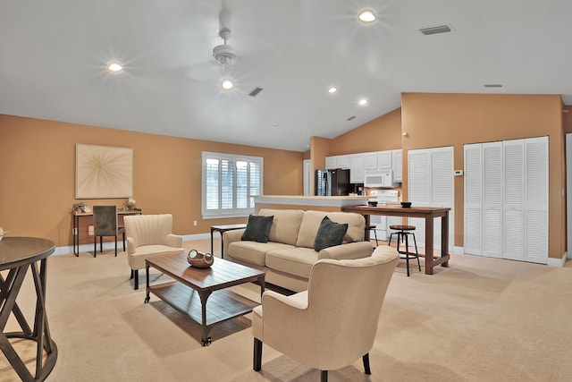 living room featuring ceiling fan, light carpet, and vaulted ceiling