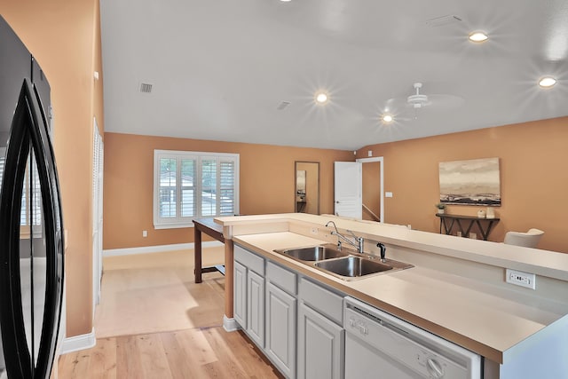 kitchen featuring white dishwasher, black fridge, sink, ceiling fan, and light wood-type flooring