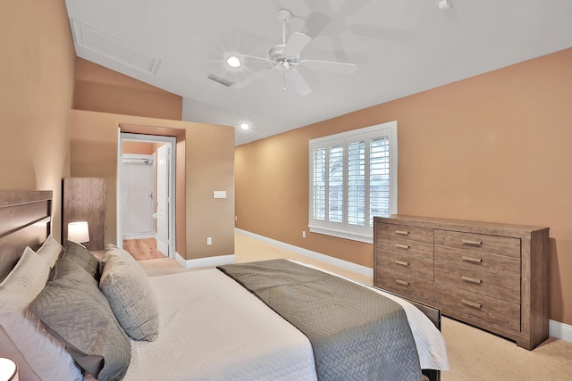 carpeted bedroom featuring ceiling fan, lofted ceiling, and ensuite bath