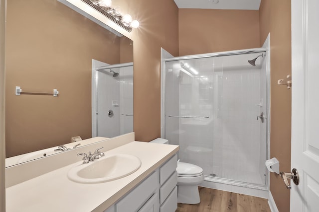 bathroom with toilet, vanity, an enclosed shower, and hardwood / wood-style flooring