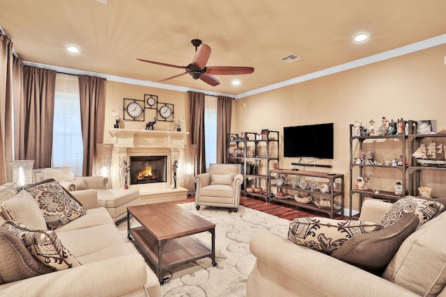 living room featuring ceiling fan, light hardwood / wood-style floors, and ornamental molding