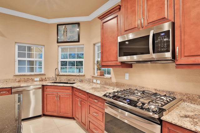 kitchen with appliances with stainless steel finishes, light stone counters, crown molding, sink, and light tile patterned flooring