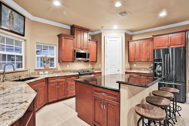 kitchen with appliances with stainless steel finishes, ornamental molding, dark stone counters, and sink