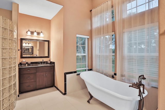 bathroom featuring tile patterned floors, vanity, and a tub to relax in