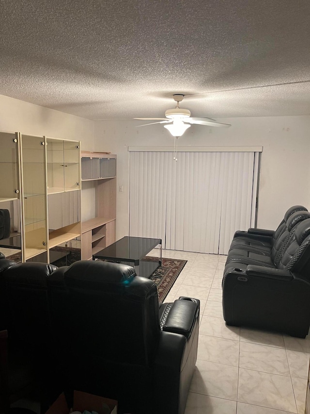 living room with a textured ceiling and ceiling fan