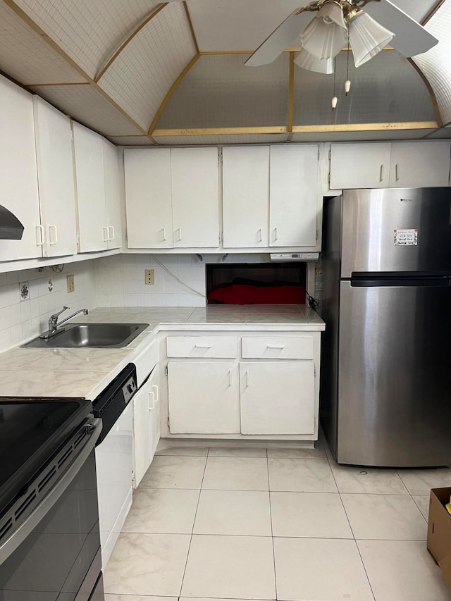 kitchen featuring backsplash, stainless steel appliances, white cabinetry, sink, and ceiling fan