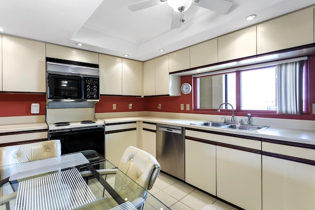 kitchen featuring sink, light tile patterned flooring, stainless steel dishwasher, electric stove, and a tray ceiling