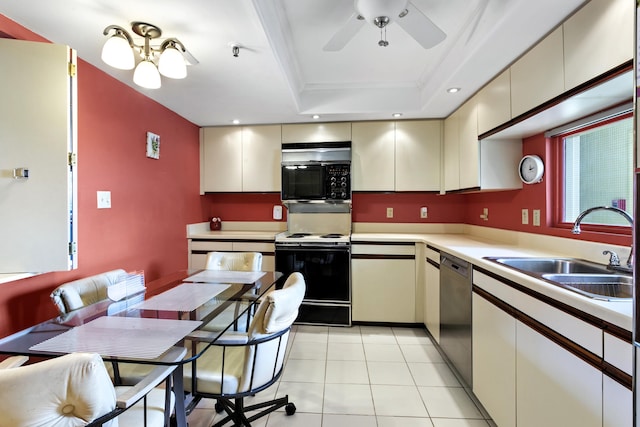 kitchen featuring black appliances, cream cabinets, a raised ceiling, and sink