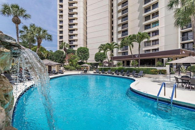 view of swimming pool with pool water feature and a patio