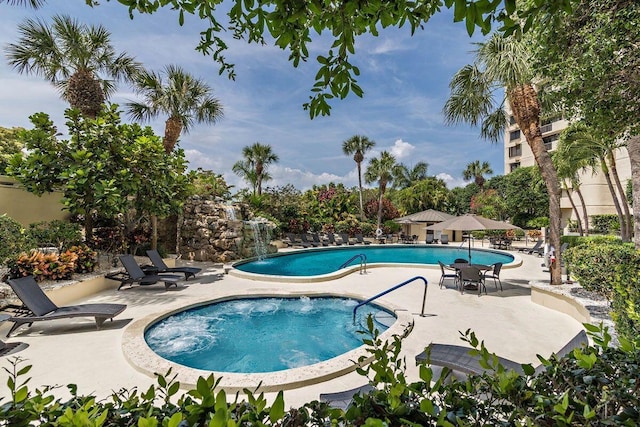 view of pool with a hot tub and a patio