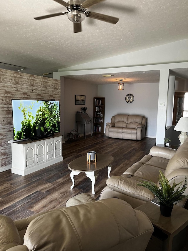 living room featuring ceiling fan, dark wood-type flooring, and a textured ceiling