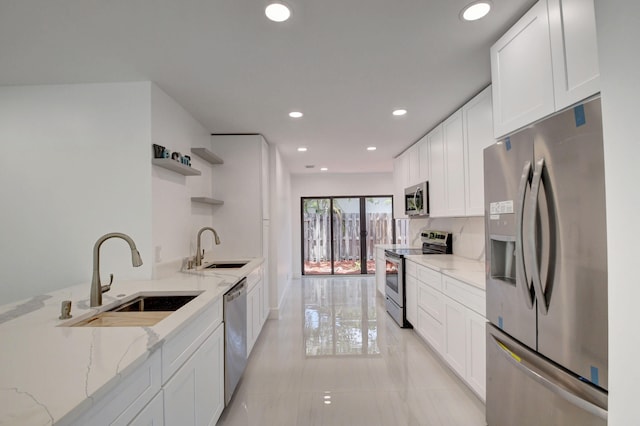 kitchen featuring white cabinets, light stone countertops, sink, and appliances with stainless steel finishes