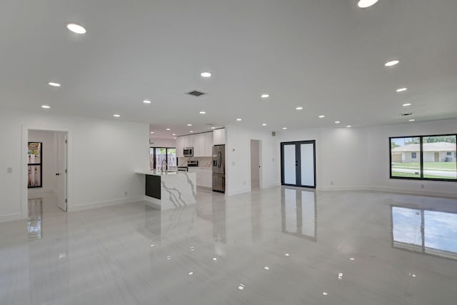 unfurnished living room featuring sink