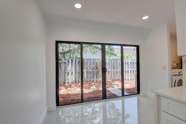 doorway with light tile patterned floors and washer / dryer