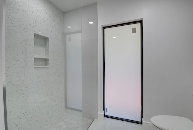 bathroom with a shower, tile patterned floors, and toilet