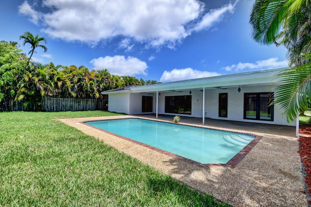 view of swimming pool with a patio area, ceiling fan, and a yard