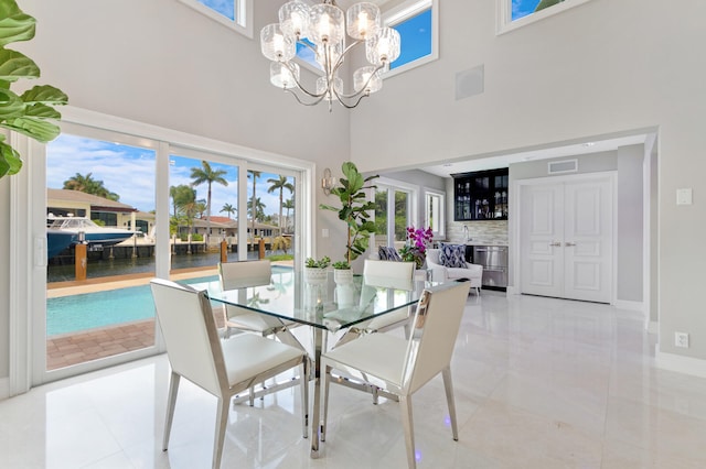 tiled dining room with a chandelier and a high ceiling