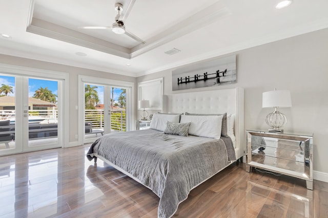 bedroom featuring access to exterior, ceiling fan, a tray ceiling, and french doors