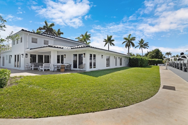 rear view of house with a yard, french doors, and a patio