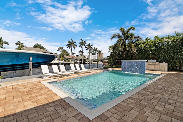 view of pool featuring a patio, pool water feature, and a boat dock