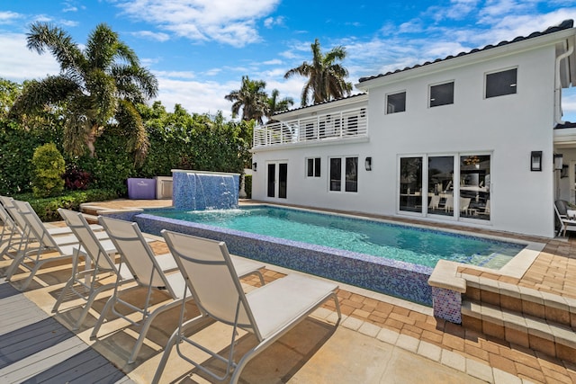 view of swimming pool with pool water feature and a patio