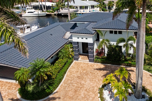 view of front of home with a garage, a dock, and a water view