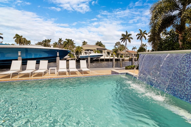 view of swimming pool featuring pool water feature and a water view