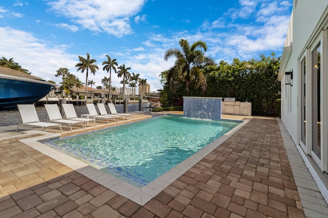 view of swimming pool with pool water feature and a patio