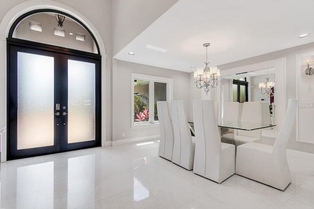 unfurnished dining area with a chandelier, light tile flooring, and french doors