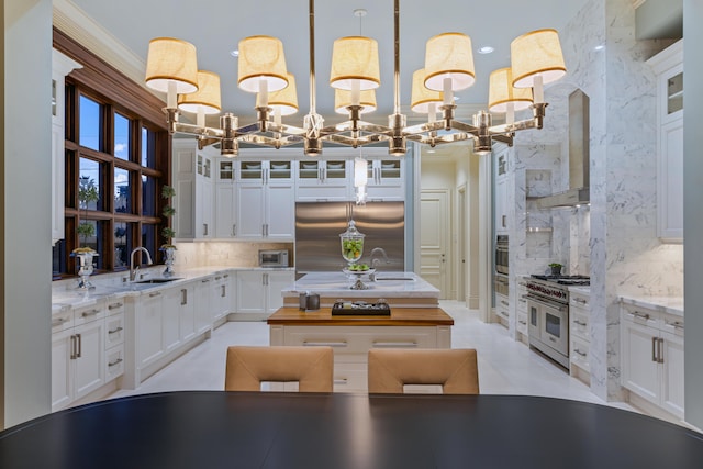 kitchen featuring backsplash, stainless steel appliances, sink, white cabinets, and hanging light fixtures