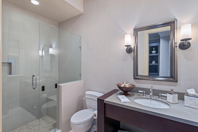 bathroom featuring vanity, toilet, a shower with shower door, and tile walls