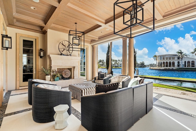 view of patio with an outdoor living space with a fireplace and a water view