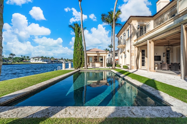 view of pool with a water view and a yard