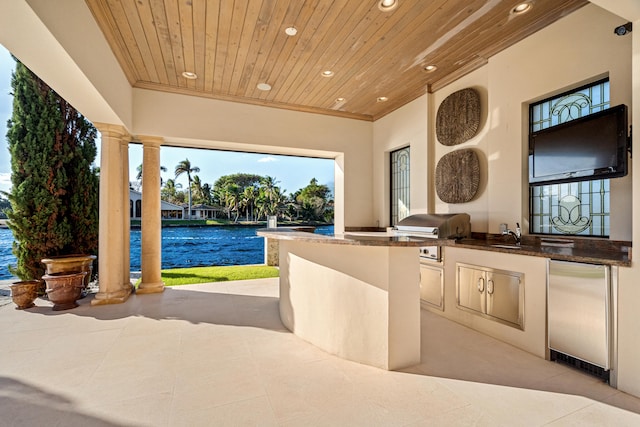 view of patio with area for grilling, sink, and exterior kitchen