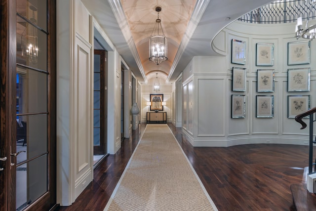 hall featuring ornamental molding, a tray ceiling, dark hardwood / wood-style flooring, and an inviting chandelier