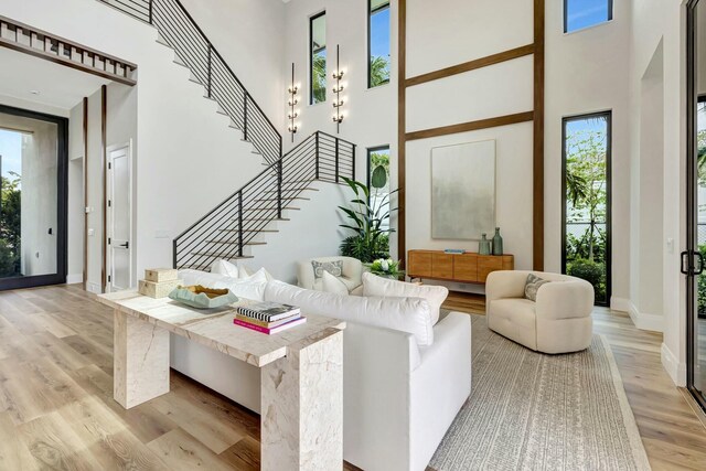 dining area with beam ceiling, light wood-type flooring, and a chandelier