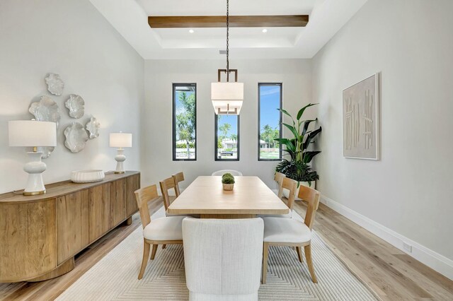 dining area with a towering ceiling and light hardwood / wood-style flooring