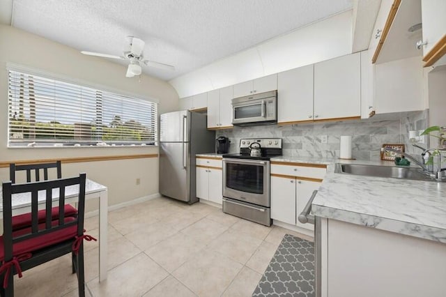 kitchen with decorative backsplash, sink, white cabinets, and stainless steel appliances