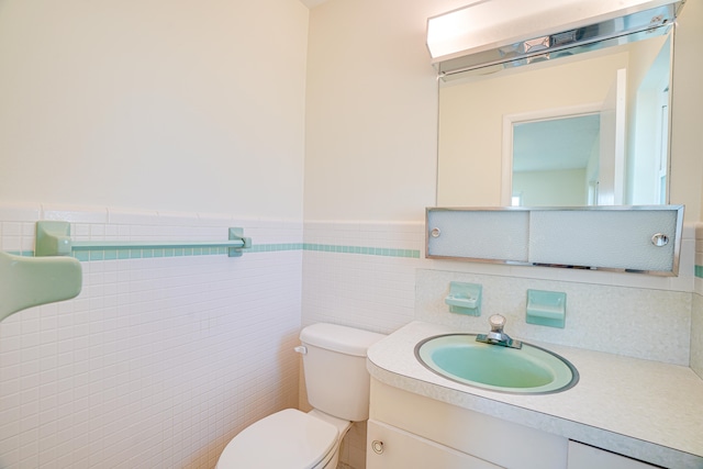 bathroom featuring vanity, tasteful backsplash, toilet, and tile walls