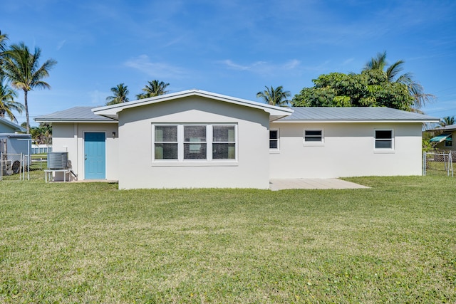 rear view of house with a patio, a yard, and central AC unit