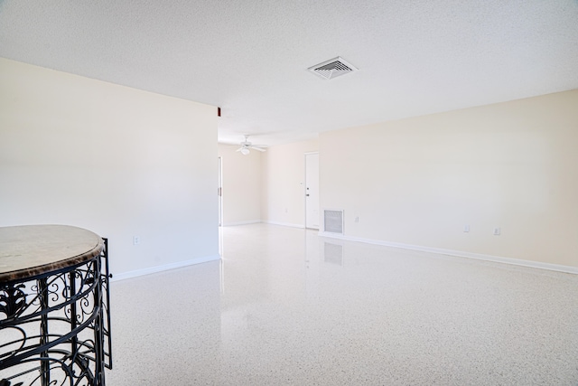 unfurnished room featuring ceiling fan and a textured ceiling